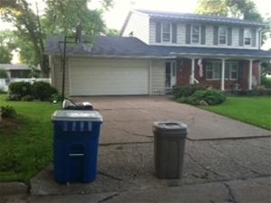 Recycling and trash bin in front of house