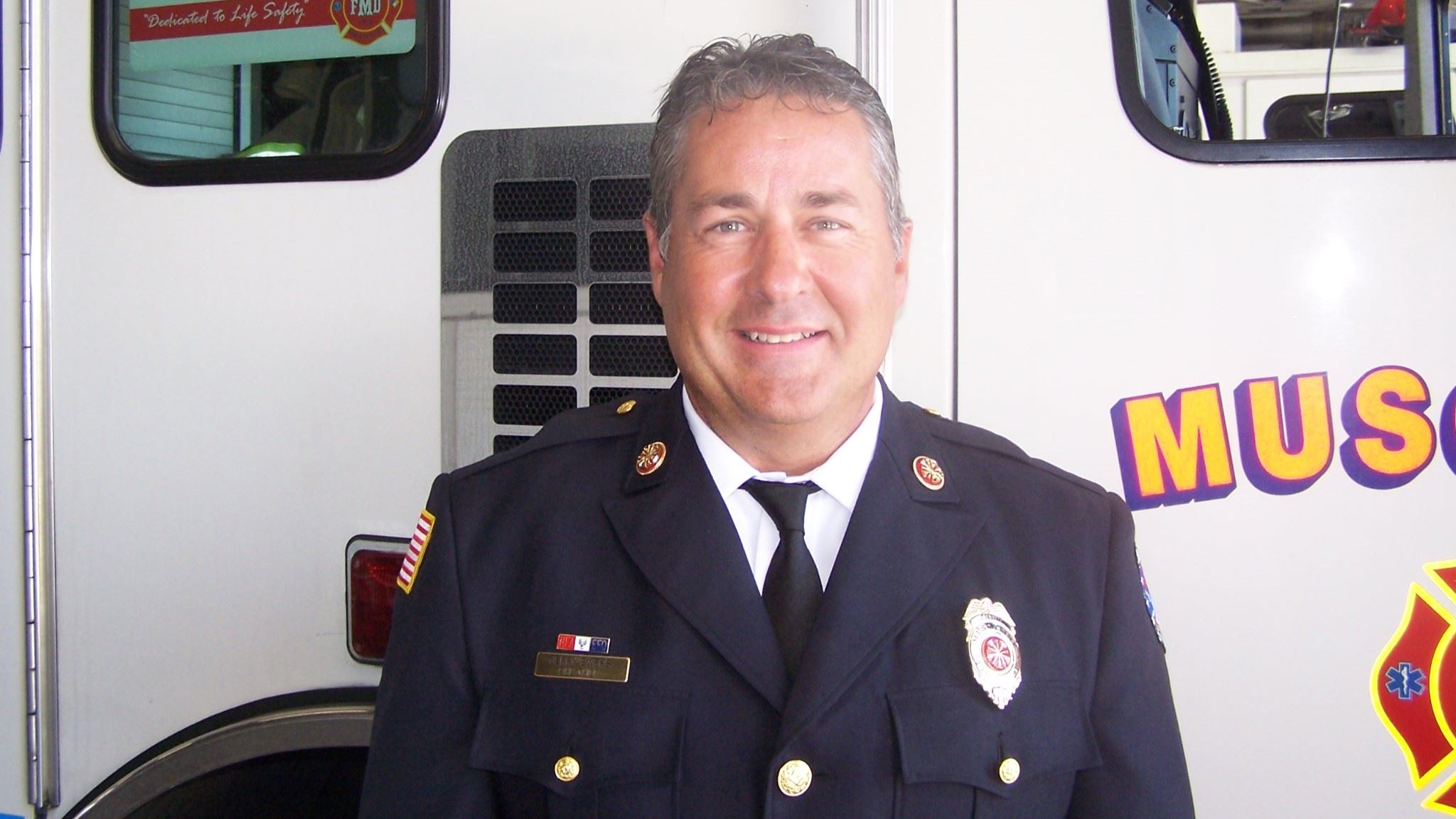 Retiring Fire Chief Jerry Ewers in front of fire truck (JPG)